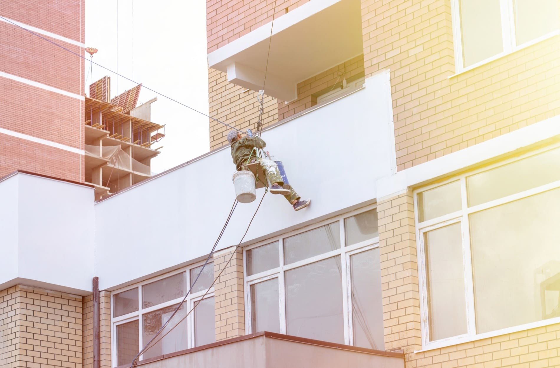 Worker painting the exterior of commercial painting