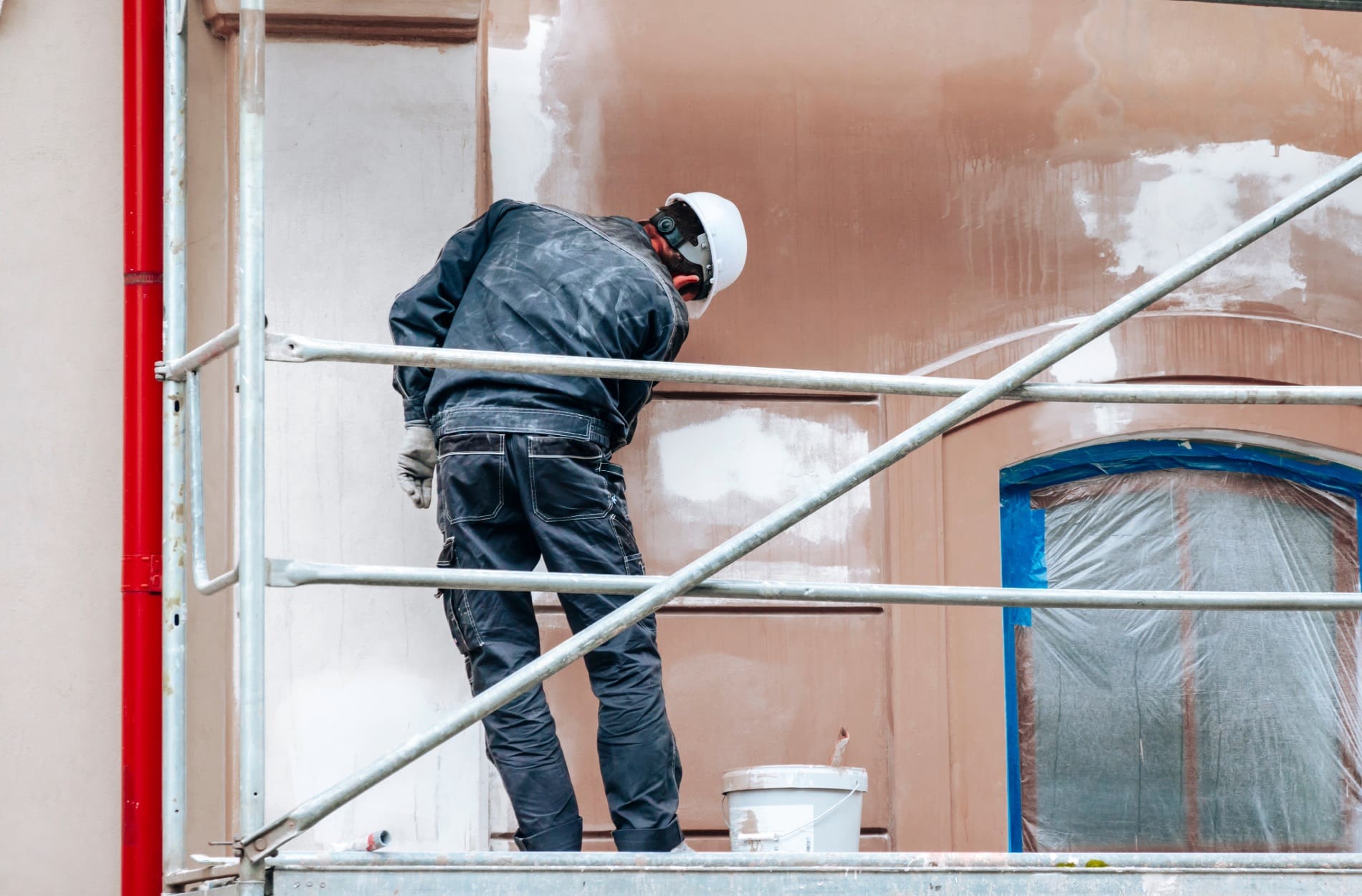 Worker painting the exterior of commercial painting