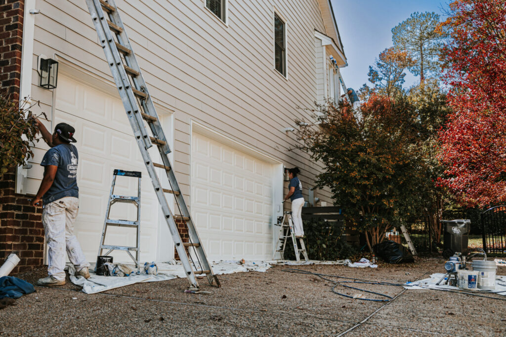 Worker painting exterior of Richmond home.