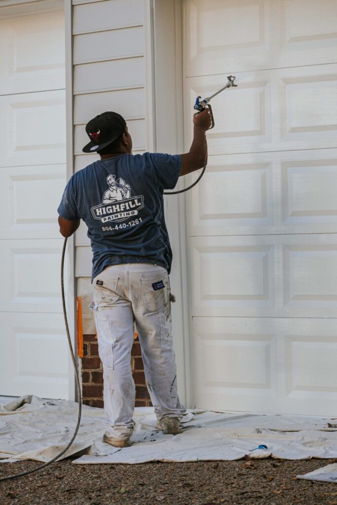 Worker painting exterior of Richmond home.